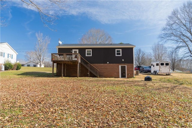 back of property with a yard and a deck