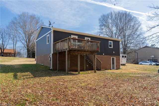 rear view of property featuring a wooden deck and a lawn