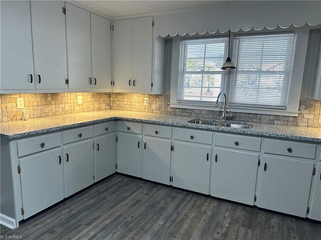 kitchen featuring white cabinetry, sink, light stone countertops, and dark hardwood / wood-style floors