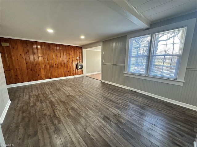 unfurnished living room featuring dark hardwood / wood-style flooring, beam ceiling, and heating unit