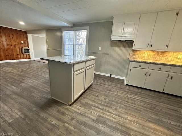 kitchen with white cabinetry, a kitchen island, dark wood-type flooring, and light stone counters