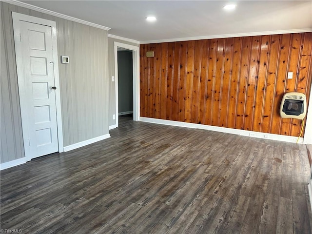 spare room featuring crown molding, dark hardwood / wood-style flooring, and heating unit