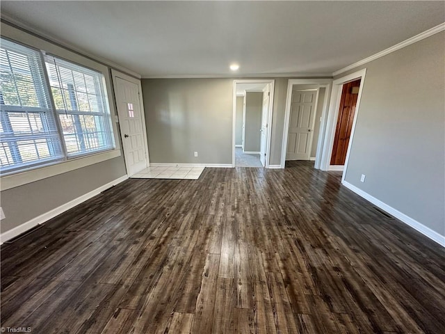 empty room with dark wood-type flooring and ornamental molding