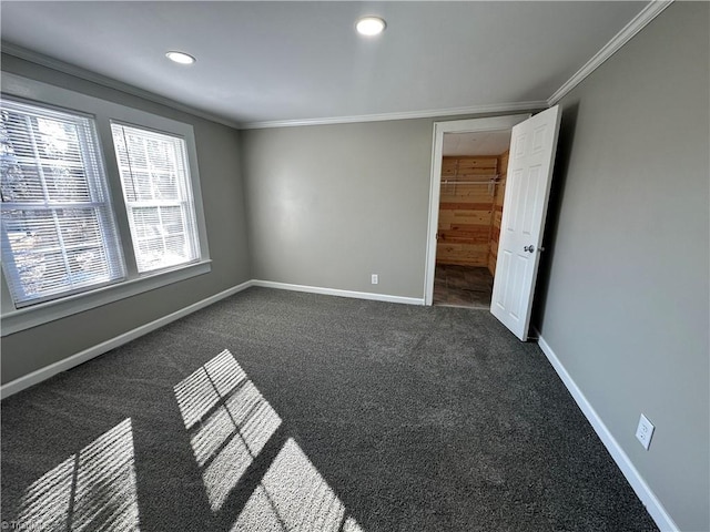 unfurnished bedroom with crown molding and dark colored carpet