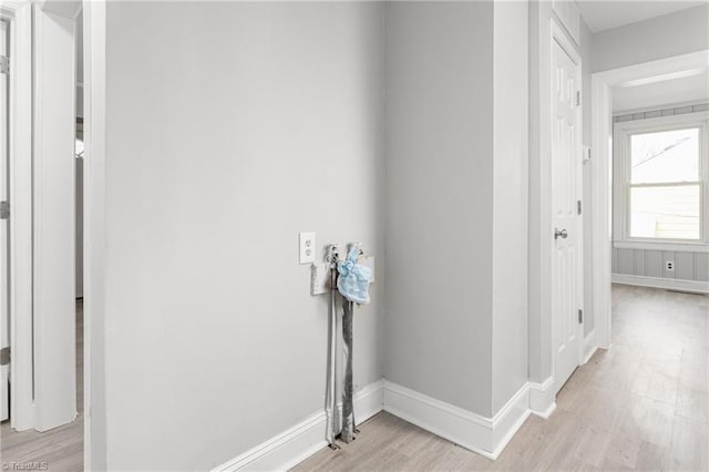 hallway with light wood-style flooring and baseboards