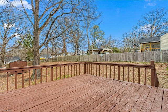 deck with an outdoor structure, a fenced backyard, and a shed