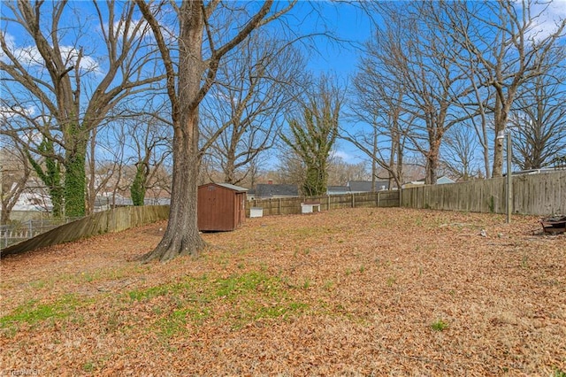 view of yard featuring an outbuilding, a shed, and a fenced backyard