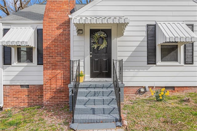 doorway to property with crawl space, a chimney, and a shingled roof