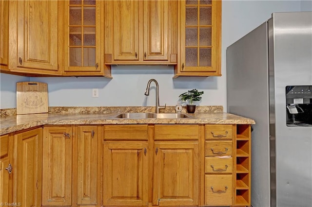 2102 Bothwell St, Greensboro, NC 27401 - kitchen with stainless steel fridge, a sink, glass insert cabinets, and light stone counters