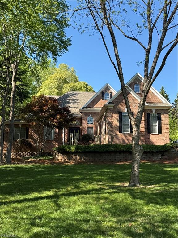 view of front of home with a front lawn and brick siding