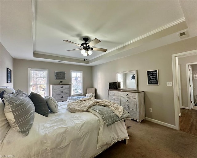 bedroom featuring ceiling fan, a raised ceiling, carpet floors, and crown molding