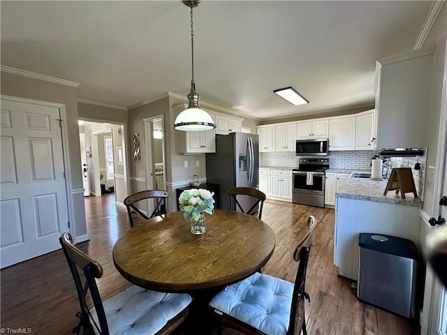 dining space featuring dark hardwood / wood-style flooring and ornamental molding