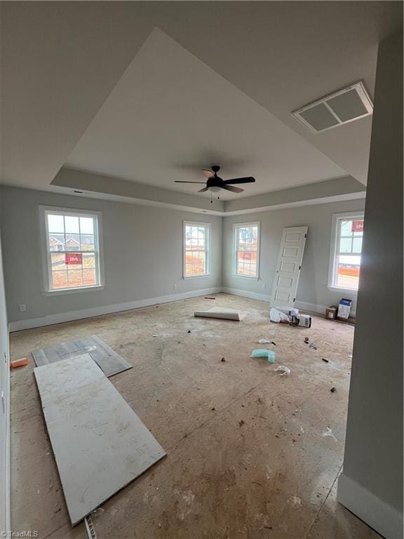 interior space with a raised ceiling and ceiling fan