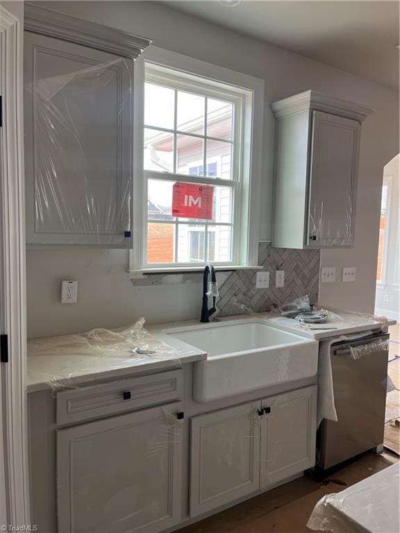 kitchen with tasteful backsplash, sink, and dishwashing machine