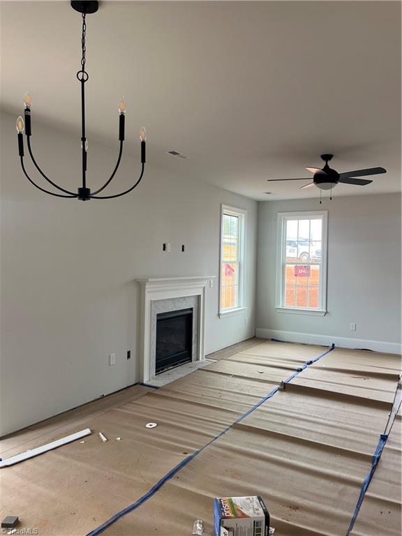 unfurnished living room with a premium fireplace and ceiling fan