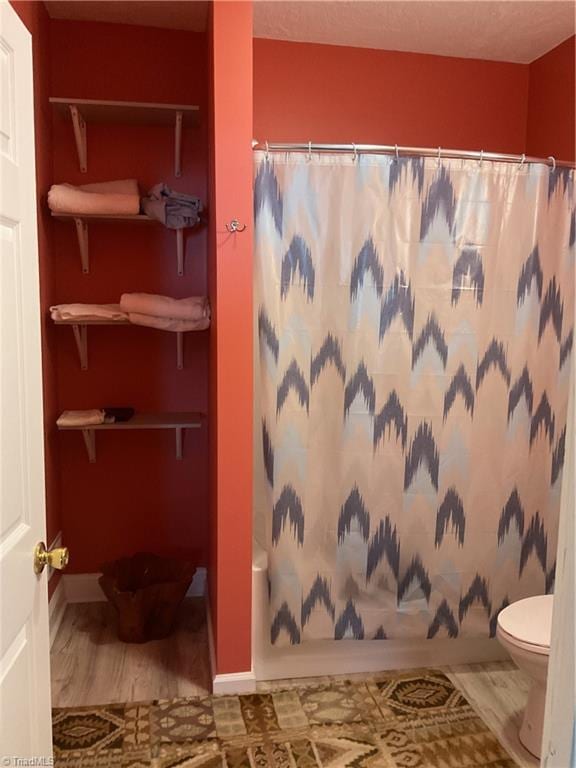 2012 Green Dr, High Point, NC 27260 - bathroom featuring toilet, wood finished floors, and baseboards