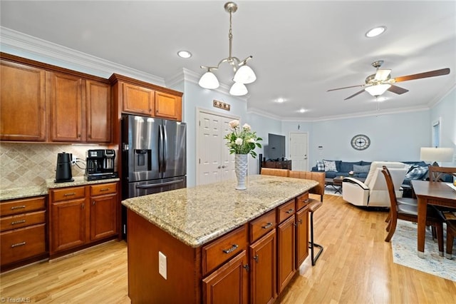 kitchen featuring tasteful backsplash, stainless steel fridge, crown molding, and light wood-style flooring