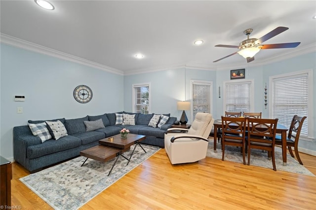 living room with crown molding, baseboards, ceiling fan, recessed lighting, and light wood-style floors