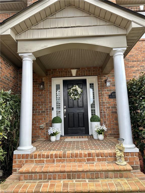 entrance to property with brick siding and covered porch