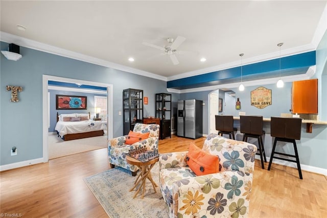 living room featuring arched walkways, light wood-style floors, crown molding, baseboards, and ceiling fan