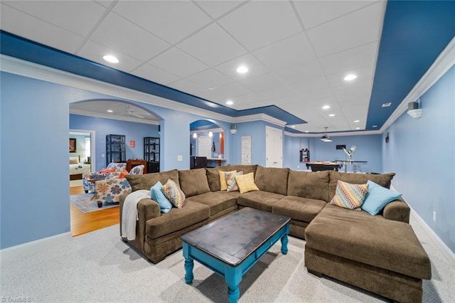 carpeted living room featuring recessed lighting, baseboards, arched walkways, and ornamental molding