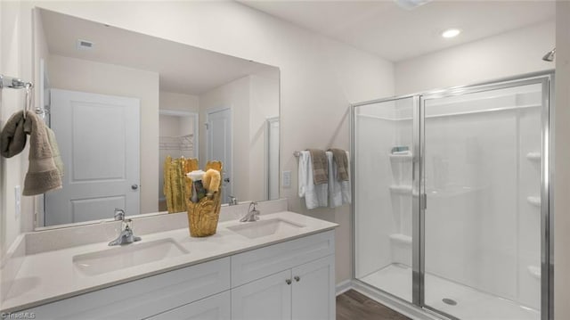 bathroom featuring hardwood / wood-style floors, vanity, and a shower with shower door