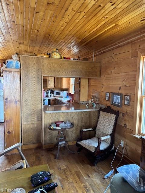 197 Mahogany Ct, Lansing, NC 28643 - kitchen featuring brown cabinets, hardwood / wood-style floors, wooden walls, wooden ceiling, and white microwave