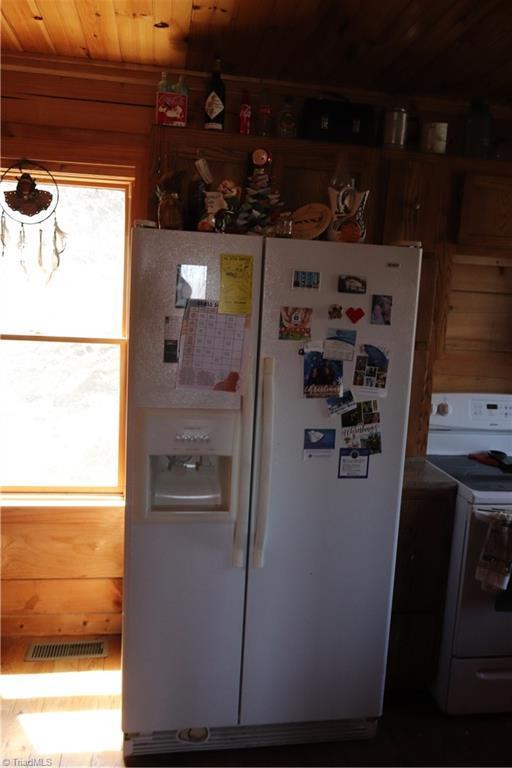197 Mahogany Ct, Lansing, NC 28643 - kitchen featuring visible vents, wooden ceiling, and white appliances