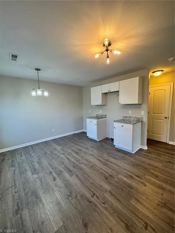 kitchen featuring white cabinetry, hanging light fixtures, dark hardwood / wood-style floors, a textured ceiling, and a chandelier