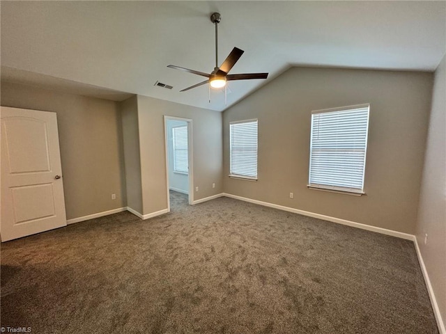 unfurnished room with vaulted ceiling, dark colored carpet, and ceiling fan