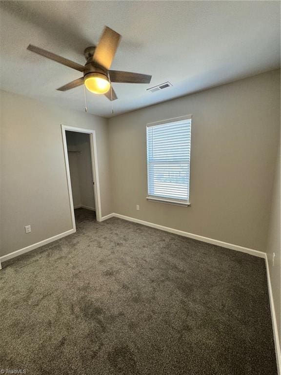 unfurnished room with ceiling fan, carpet floors, and a textured ceiling