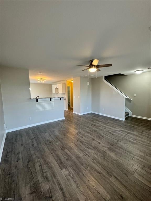 unfurnished living room with ceiling fan and dark hardwood / wood-style flooring