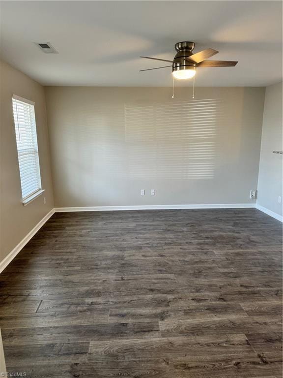 empty room featuring dark hardwood / wood-style flooring and ceiling fan