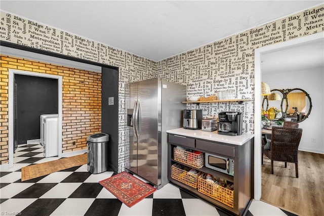 kitchen featuring tile patterned floors, washer / clothes dryer, and stainless steel refrigerator with ice dispenser