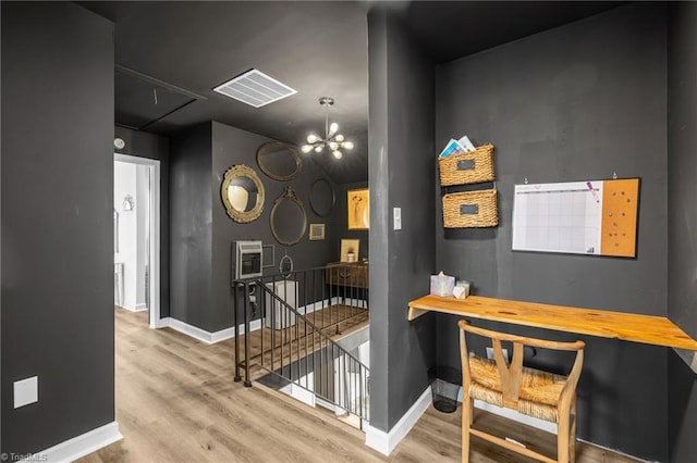 interior space with visible vents, baseboards, an inviting chandelier, and wood finished floors