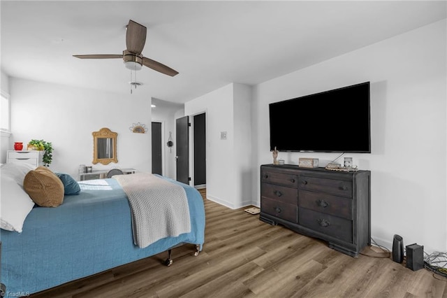 bedroom featuring ceiling fan, baseboards, and wood finished floors