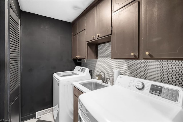 laundry room with a sink, cabinet space, and washing machine and dryer