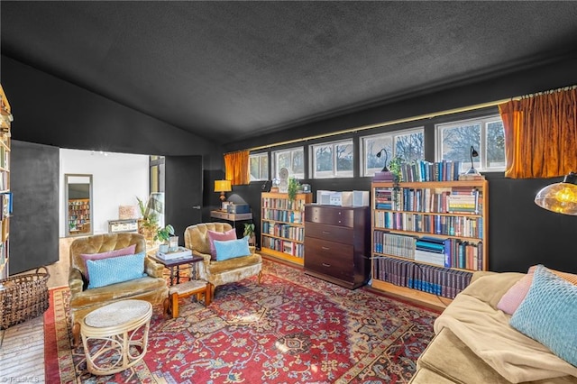 living area featuring lofted ceiling, a textured ceiling, and wood finished floors