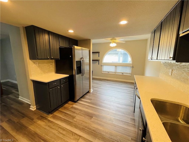 kitchen with stainless steel refrigerator with ice dispenser, backsplash, and light wood-type flooring