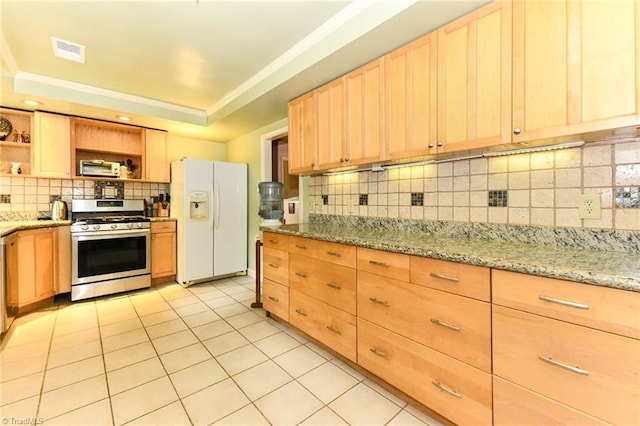 kitchen with light brown cabinets, stainless steel range with gas cooktop, a tray ceiling, white refrigerator with ice dispenser, and open shelves