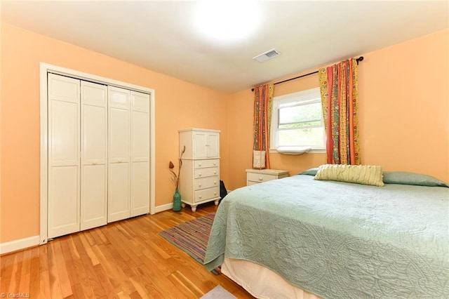 bedroom featuring visible vents, baseboards, a closet, and light wood finished floors