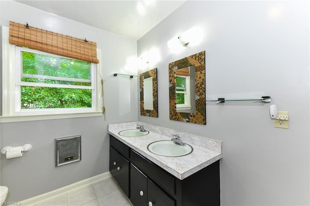 full bathroom with a sink, baseboards, double vanity, and tile patterned floors