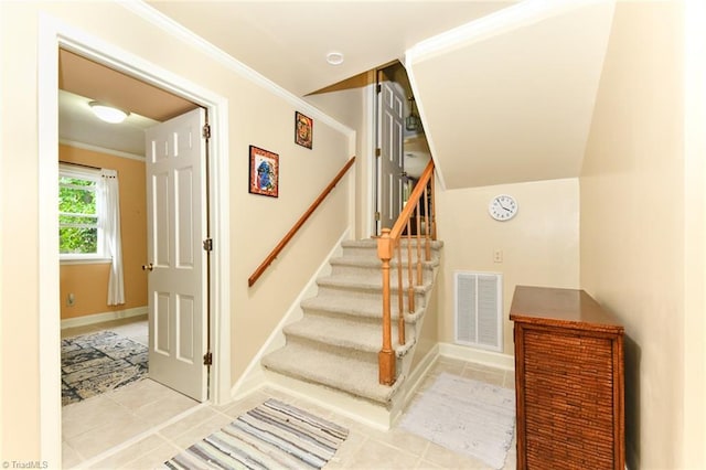 stairs with tile patterned flooring, crown molding, baseboards, and visible vents