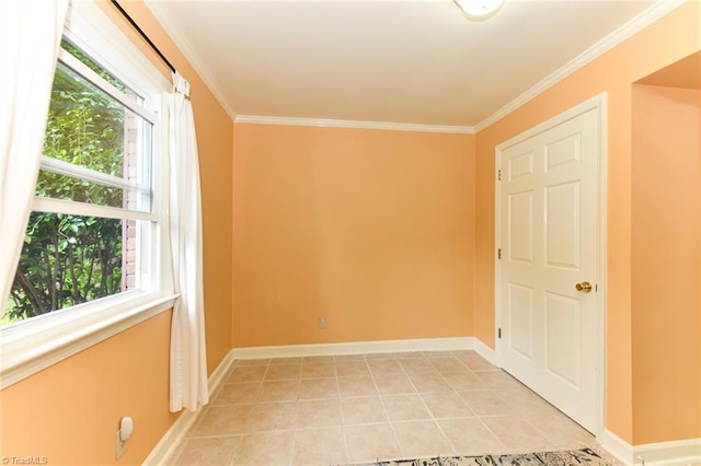 spare room featuring baseboards, ornamental molding, and light tile patterned flooring