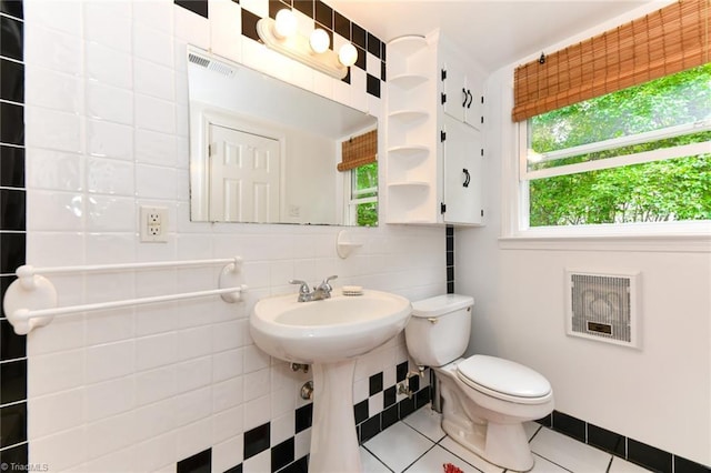 half bathroom featuring tile patterned flooring, visible vents, backsplash, toilet, and heating unit