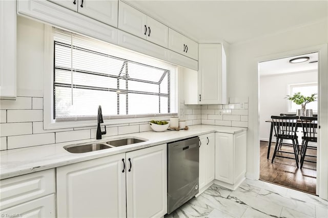 kitchen with backsplash, white cabinets, sink, stainless steel dishwasher, and light stone counters