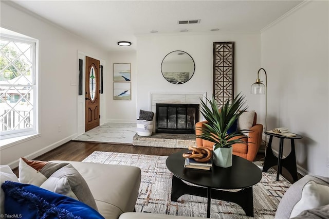 living room featuring dark hardwood / wood-style floors, ornamental molding, and a fireplace