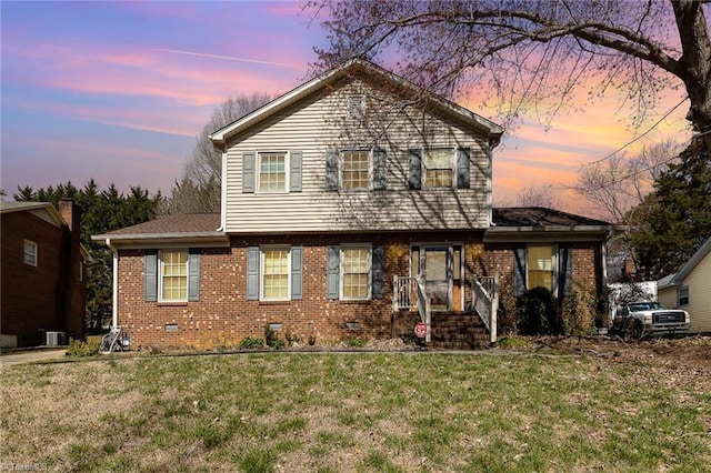 view of front facade featuring a front yard, crawl space, and brick siding