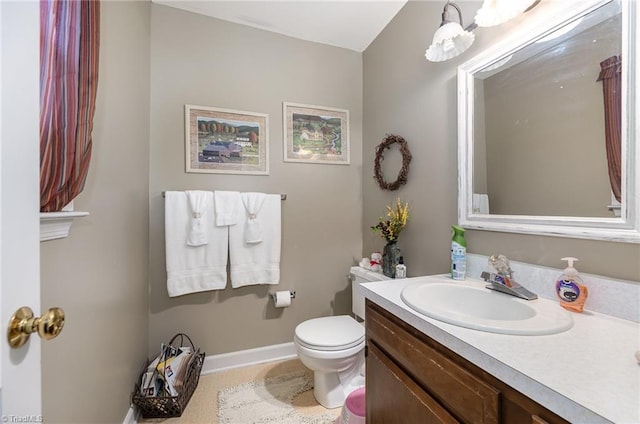 bathroom featuring baseboards, vanity, and toilet