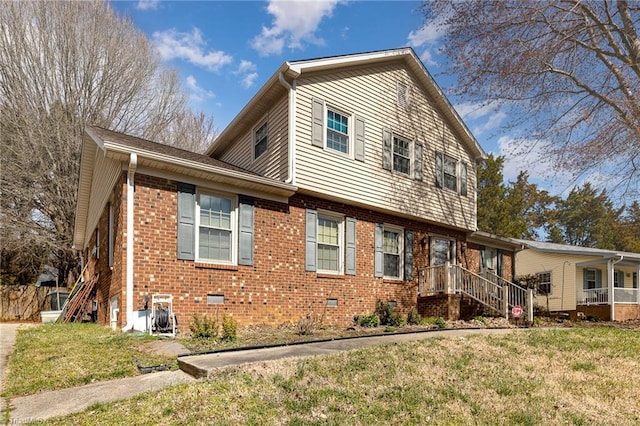 view of front facade featuring crawl space, brick siding, and a front lawn